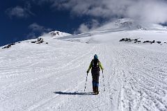 04A My Guide Liza Pahl Leads The Way On The Climb To Pastukhov Rocks With Mount Elbrus West And East Summits Above.jpg